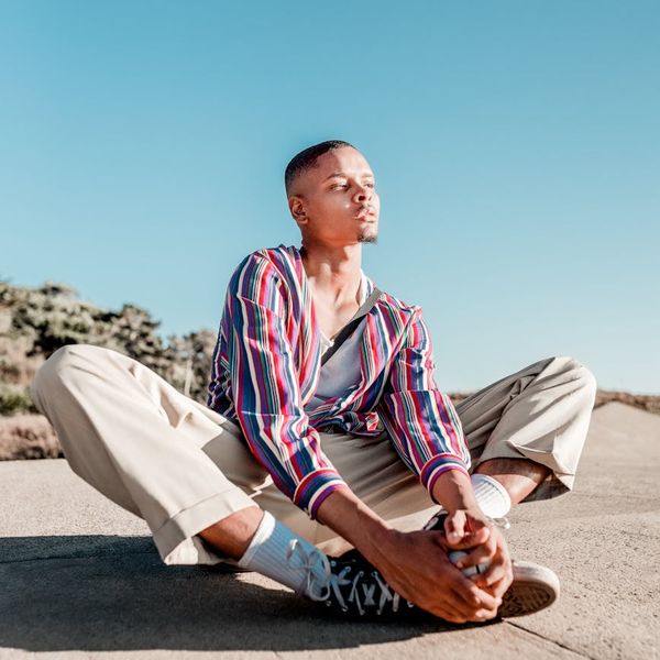 Person meditating peacefully outdoors during a sunny day.